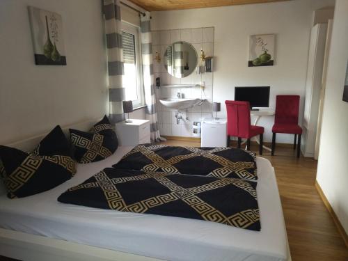 a bedroom with a bed and a bathroom with a sink at Pension Breidbach in Ensch