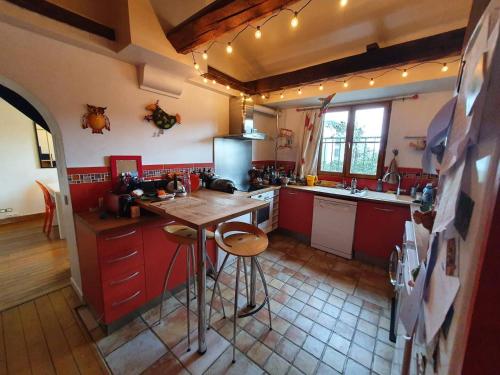 une cuisine avec des placards rouges et un comptoir en bois dans l'établissement Appartement 5 chambres au dernier étage, à Paris