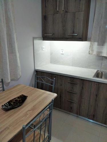 a kitchen with a wooden table and a sink at Chris&Chris Luxury apartment in Mesolongion