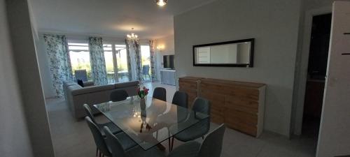 a dining room with a glass table and chairs at Mazurskie Wzgorze Bis z basenem in Rydzewo