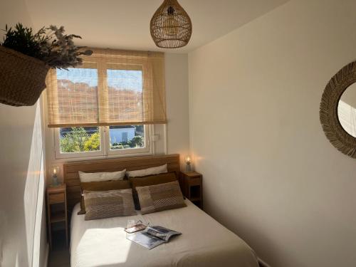 une chambre avec un lit et une fenêtre dans l'établissement Terrasse Vue Mer - Appartement 6 pers, 3 chambres et Parking à St Tropez, à Saint-Tropez