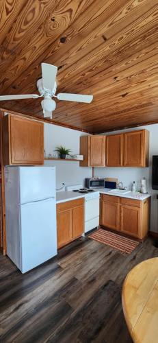 cocina con nevera blanca y techos de madera en Hawks Nest Loft, en Crawfordville