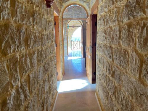 an empty hallway with a stone wall and an archway at Hoopoe lodge in Tunis