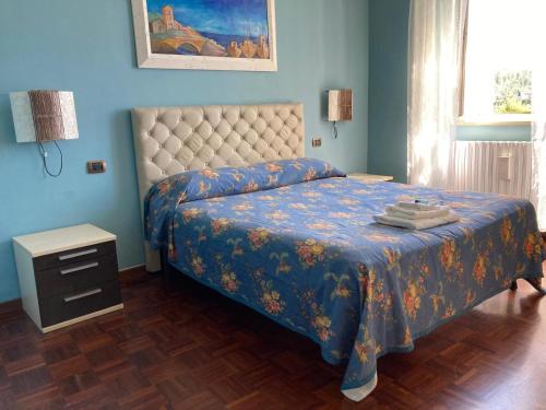 a bedroom with a bed with a blue wall at Appartamento Forte Malatesta in Ascoli Piceno