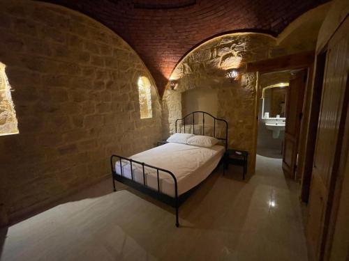 a bedroom with a bed in a brick wall at Hoopoe lodge in Tunis