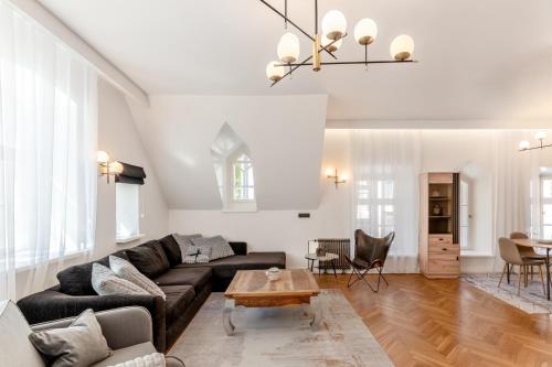 a living room with a couch and a table at 2BR 95m2 apartment in Old Town with Free Parking and Sauna! in Tallinn