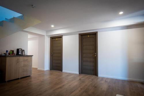 an empty room with two doors and wooden floors at White House in Târgu Jiu