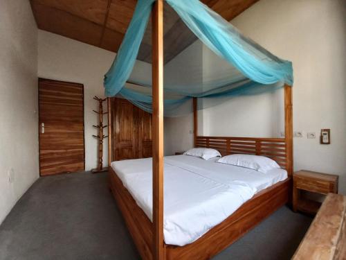 una camera con letto in legno a baldacchino di Villa Jardin d' Eden a Lomé