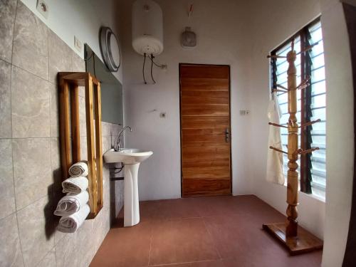 bagno con lavandino e porta in legno di Villa Jardin d' Eden a Lomé