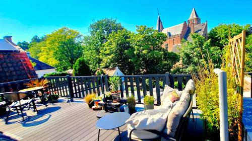 a deck with a couch sitting on top of it at Bela Vista in Burgh Haamstede