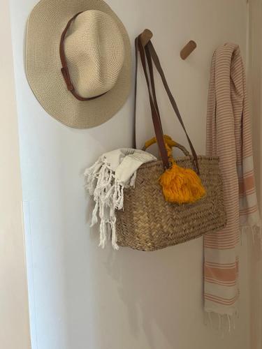 un chapeau de paille et un panier suspendu sur un mur dans l'établissement Terrasse Vue Mer - Appartement 6 pers, 3 chambres et Parking à St Tropez, à Saint-Tropez