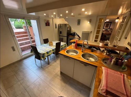 une cuisine et une salle à manger avec deux éviers et une table dans l'établissement T - Maison 5 chambres 3 min metro RER - PARC EXPO, à Bourg-la-Reine