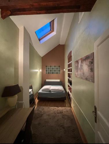 une chambre avec un lit et une lucarne dans l'établissement T - Maison 5 chambres 3 min metro RER - PARC EXPO, à Bourg-la-Reine