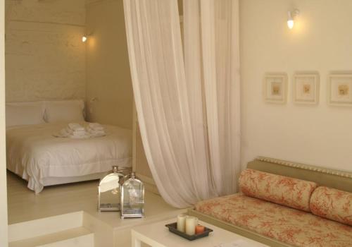 a room with a bed and a couch with a window at Katikies Manis in Kardamili