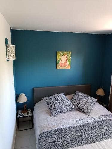 une chambre avec un mur bleu et un lit dans l'établissement Moon location, au Cap d'Agde