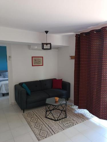 un salon avec un canapé et une table dans l'établissement Moon location, au Cap d'Agde