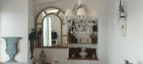 Cette chambre comprend un lustre et un miroir. dans l'établissement F2 Vieux Village Roquebrune Cap Martin RCM, à Roquebrune-Cap-Martin