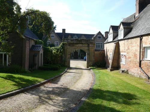 Great GlenにあるThe Garden Room at the Manorの家々が立ち並ぶ村の古い石造りのアーチ道