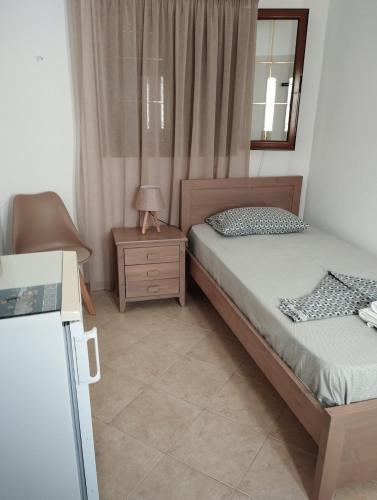 a bedroom with two beds and a table and a mirror at ANATOLI ROOMS SERIFOS in Serifos Chora