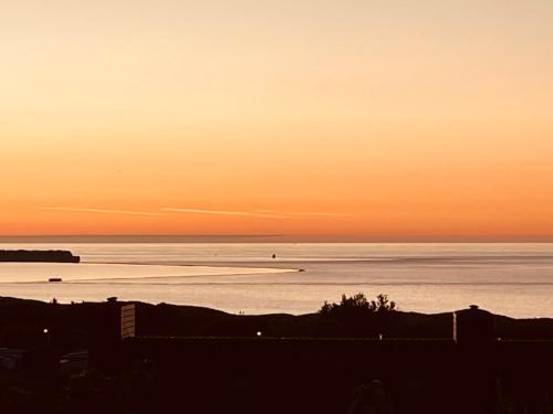 a view of the ocean at sunset at Gite proche mer in Cherbourg en Cotentin
