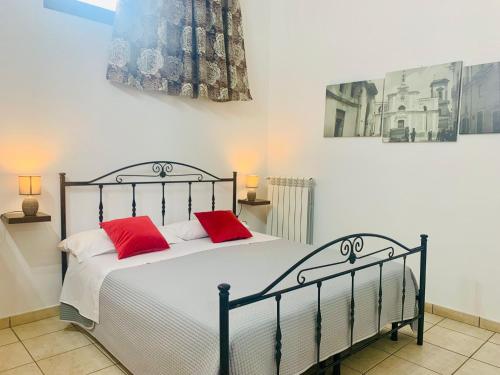 a bedroom with a bed with two red pillows at Salento Holiday Casa Vacanze in Magliano