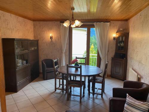 une salle à manger avec une table et des chaises en bois dans l'établissement Grand gîte rural 8-10p à la montagne avec jardin, à Corps