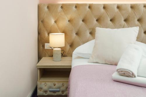 ein Schlafzimmer mit einem Bett und einer Lampe auf einem Nachttisch in der Unterkunft Hotel Stella Maris - Style & Comfort in Vodice