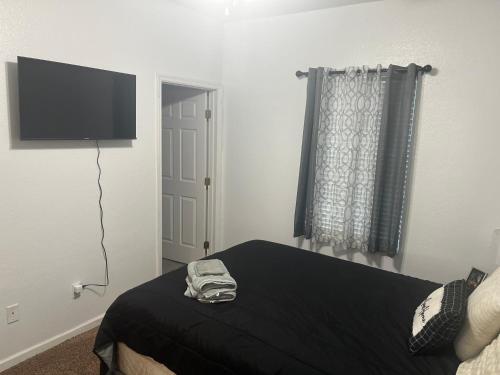 a bedroom with a bed and a flat screen tv at 3 Bed 3 Bath Townhome in Tallahassee