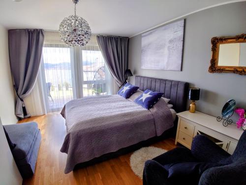 a bedroom with a bed and a large window at Bjørnestrand Fjordside View in Bergen