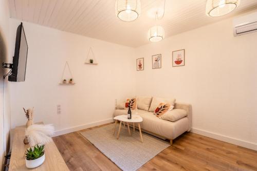 a living room with a couch and a table at T2 climatisé proche de Montpellier avec parking public ! in Saint-Georges-dʼOrques