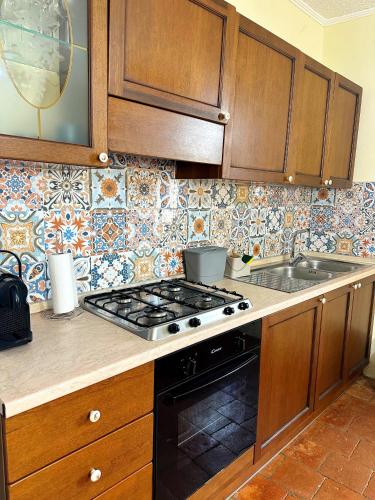 a kitchen with wooden cabinets and a stove top oven at Appartamento La Locanda Del Castello in San Panfilo dʼOcre