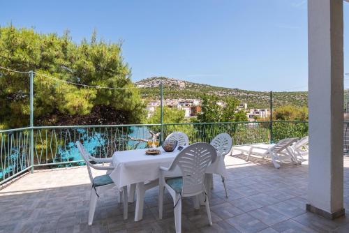 a white table and chairs on a patio with a view at Apartments Ivica in Primošten