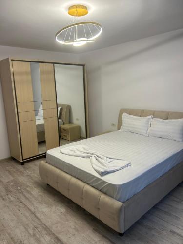 a bedroom with a large bed and a mirror at Apartament Emma in Mangalia