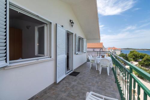 a balcony of a house with a table and chairs at Apartments Ivica in Primošten