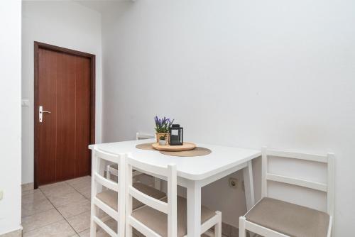 a white table and chairs in a room at Apartments Ivica in Primošten