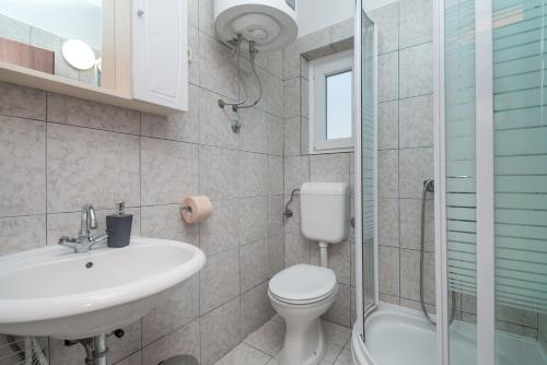 a bathroom with a toilet and a sink and a shower at Apartments Ivica in Primošten