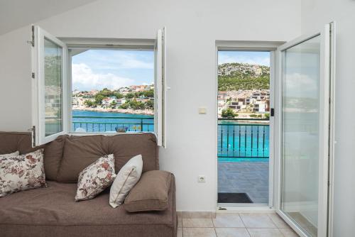 a living room with a couch and sliding glass doors at Apartments Ivica in Primošten
