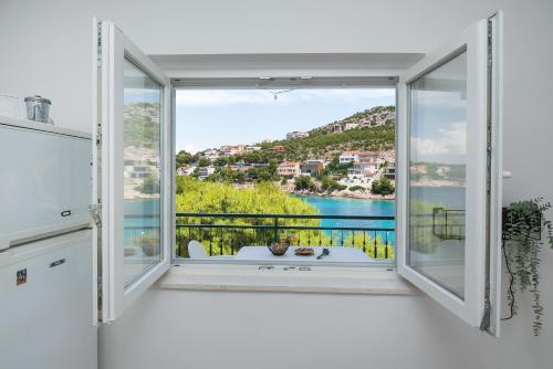 a room with a window with a view of the water at Apartments Ivica in Primošten