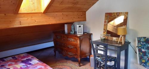 - une chambre avec une commode, un miroir et un lit dans l'établissement Studio Résidence Val d'Escreins, à Guillestre