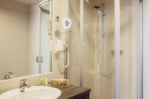 a bathroom with a shower and a sink at ETO Park Hotel Business & Stadium in Győr