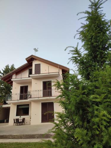a white building with a balcony and a tree at San Nicola in Agerola