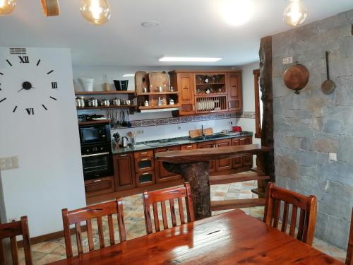 a kitchen with a table and a clock on the wall at Casa rural SOROA landetxea in Arantza