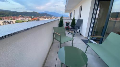 a balcony with chairs and tables on a building at Apartament Ovy Residence Râșnov in Râşnov