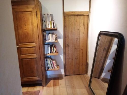 a mirror in a room with a book shelf at Chambres D'hôtes LES PAPILLONS in Mars