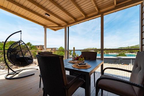 a patio with a table and chairs on a deck at Mobile home Dragon Bay - Fimen in Drage