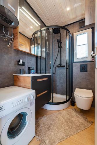 a bathroom with a shower and a washing machine at Mobile home Dragon Bay - Fimen in Drage