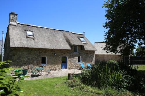 an old stone house with blue chairs and tables at Ti-Plouz in Caudan