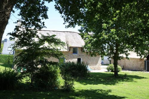 an old stone house with a thatched roof at Ti-Plouz in Caudan