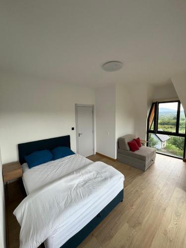 a bedroom with a large bed and a chair at Panorama Kosmaj in Drumine