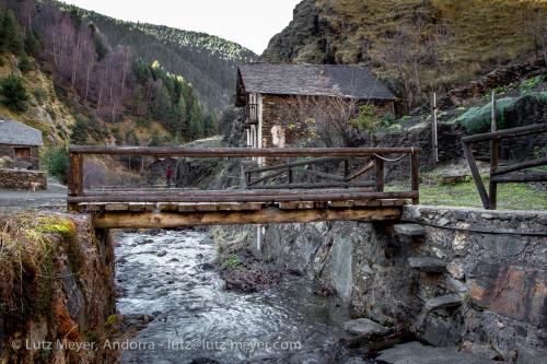 a wooden bridge over a river in a mountain at Apartaments Sort Pirineus in Sort